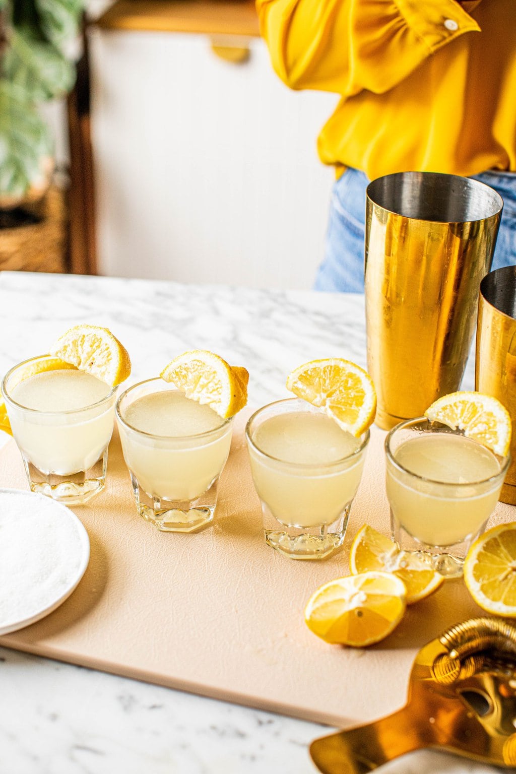 lined up lemon drop shots with lemon wedges on cutting board