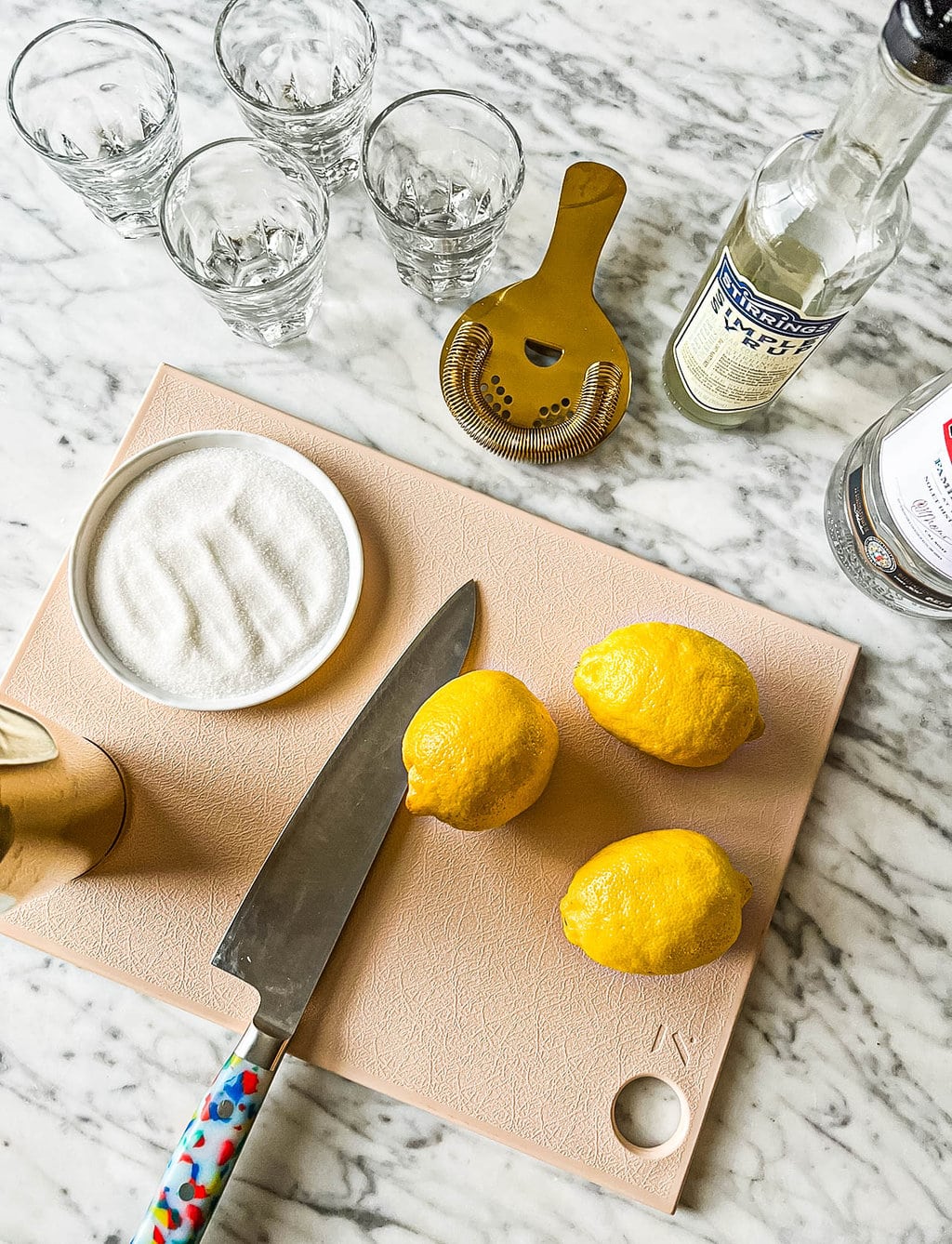 cocktail shaker, lemons, sugar, simple syrup, vodka, knife, cutting board