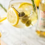 white spritz bianco garnished with lemon slices, rosemary and green olives