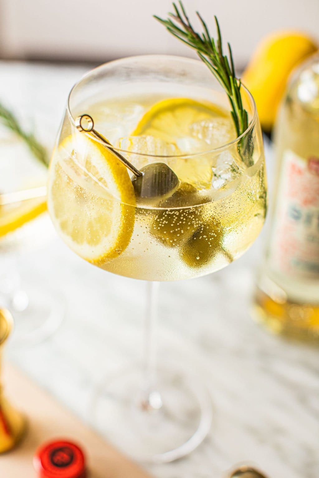 white spritz bianco garnished with lemon slices, rosemary and green olives