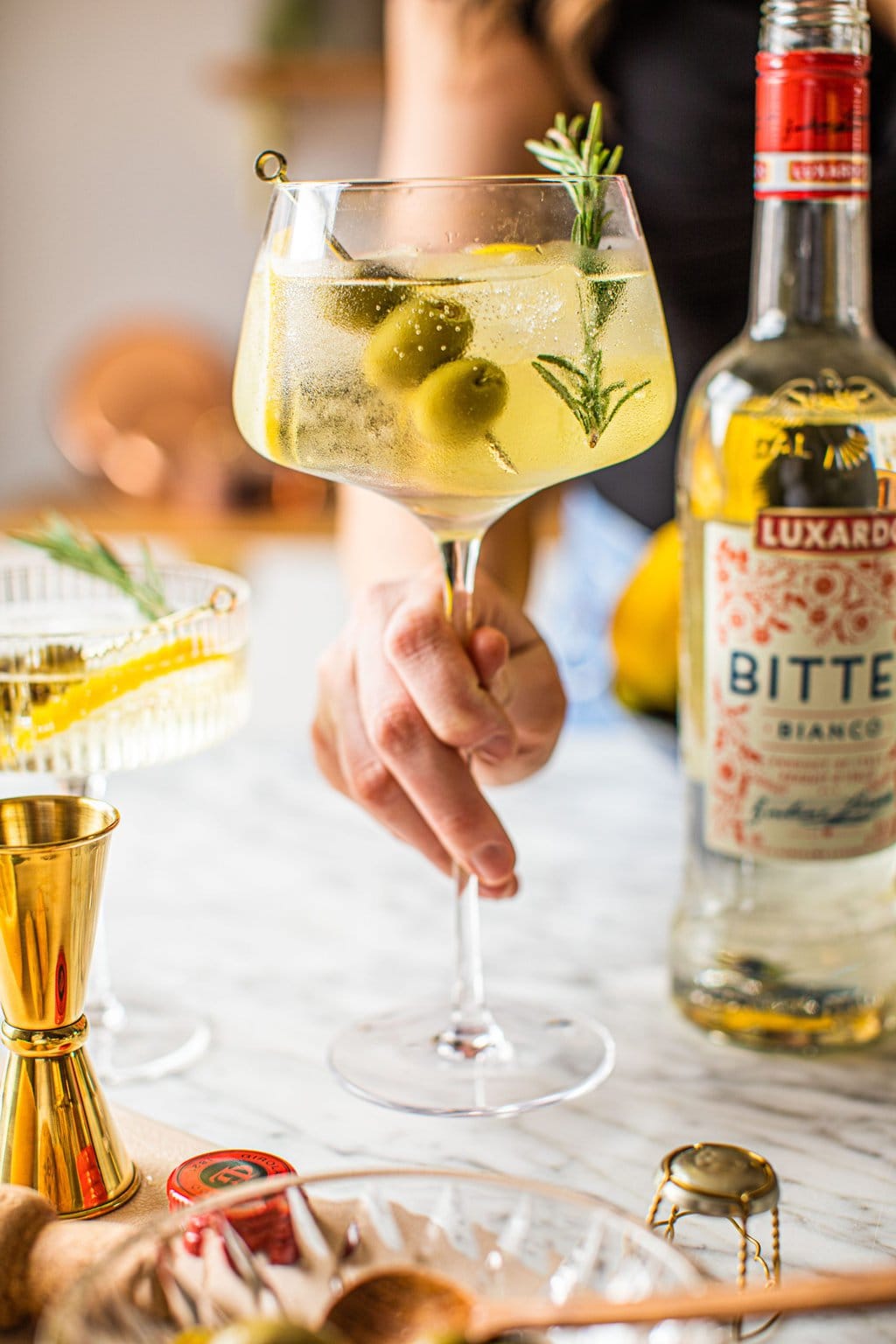 woman holding spritz bianco in white glass