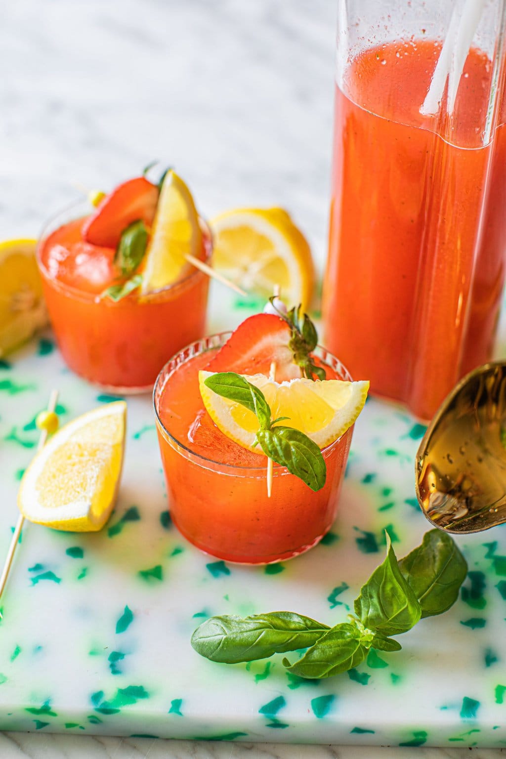 strawberry basil lemonade mocktail garnished with strawberry and fresh lemon wedge