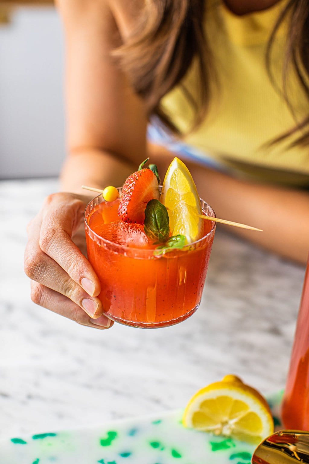 woman holding glass of strawberry basil lemonade