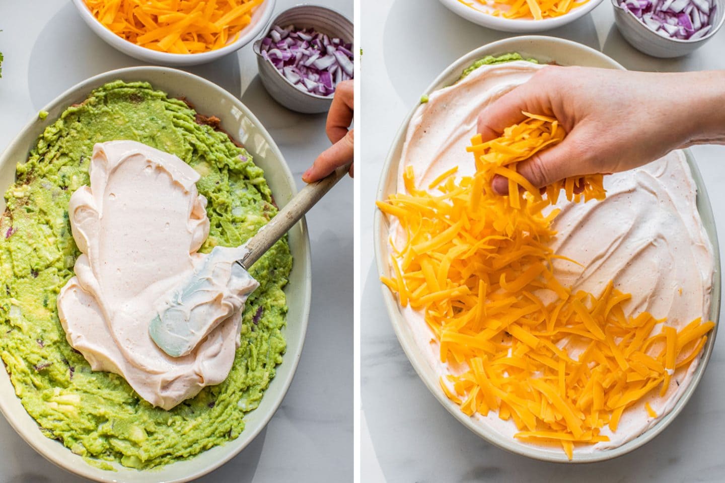 adding the sour cream layer over the guacamole and then sprinkling cheddar cheese on top