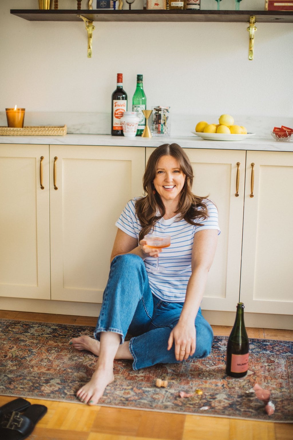 girl sitting in front of cream kitchen colored cabinets 