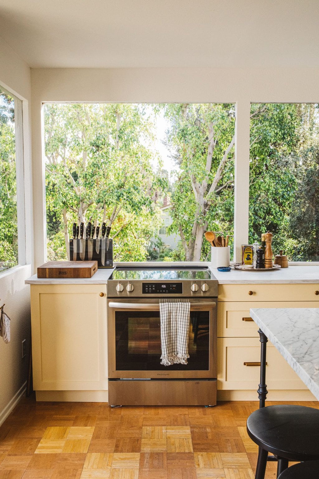 pool house kitchen with large windows and a stainless steel electric stove 