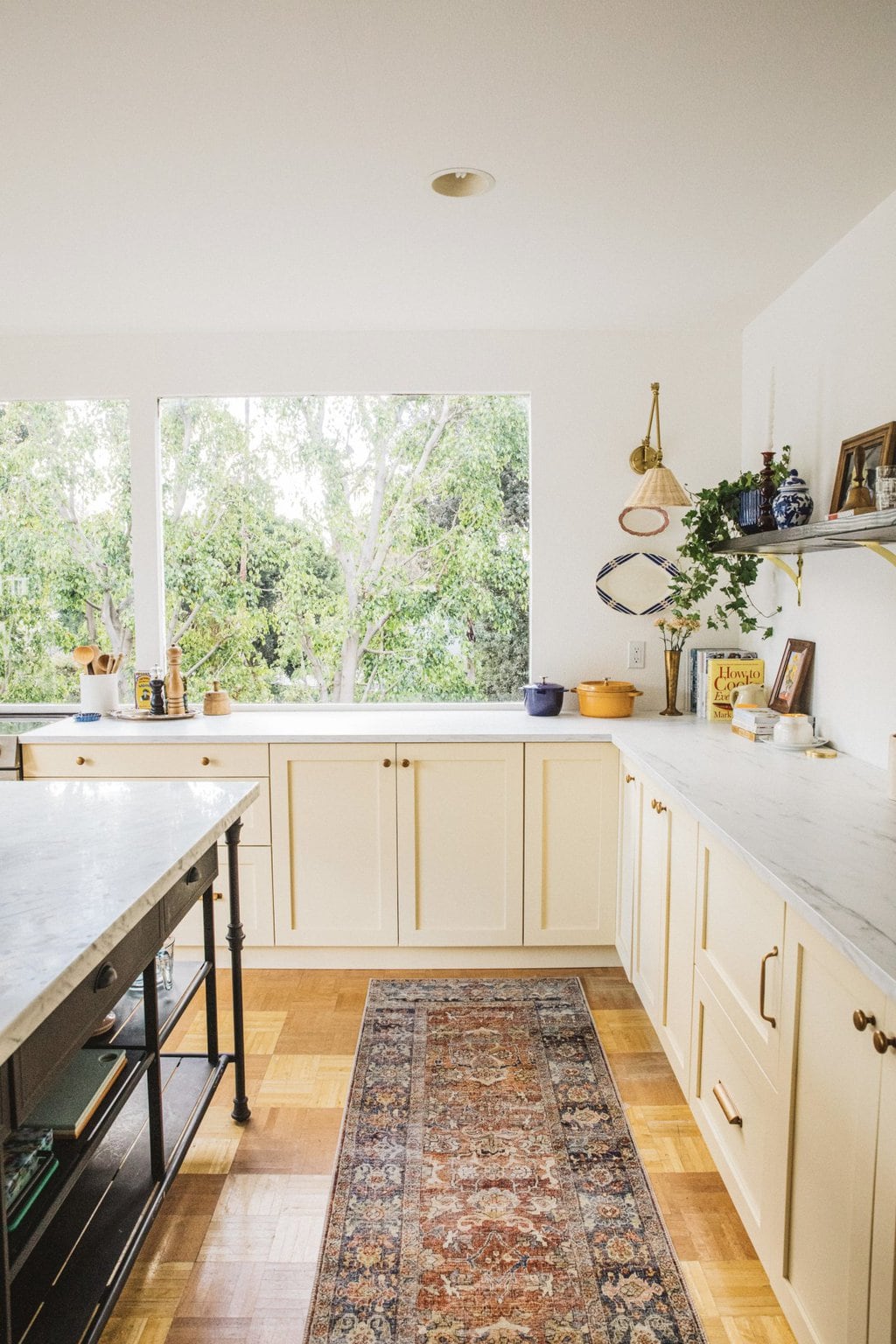 pool house kitchen with large windows, open shelving and cream cabinets 