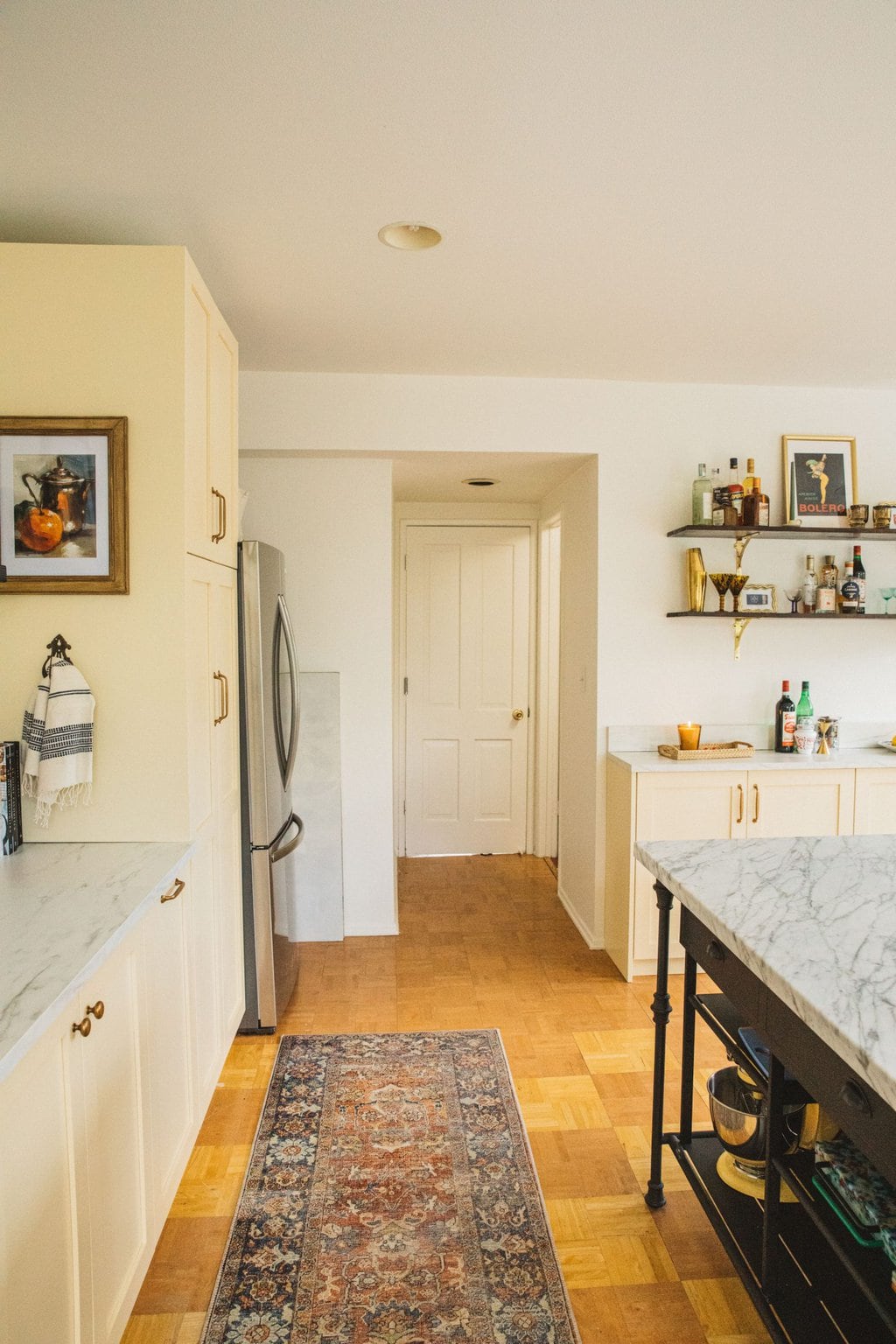 cream kitchen cabinets, red and blue persian runner, marble island, cream colored cabinets 