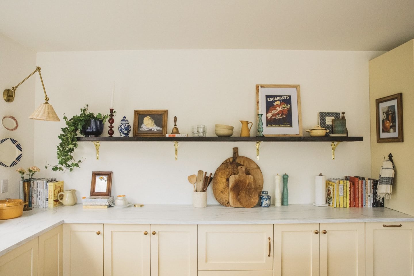 kitchen with white walls, open shelving, colorful decor and cream cabinets 