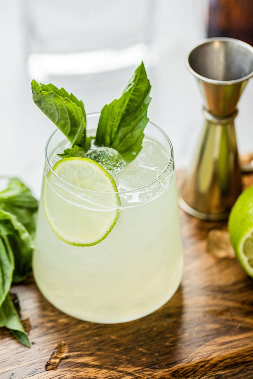 a glass of gin basil smash with lime and basil as garnish