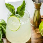 a glass of gin basil smash with lime and basil as garnish