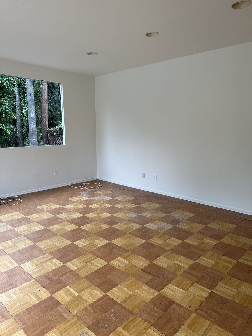 empty pool house with large windows and wood flooring 