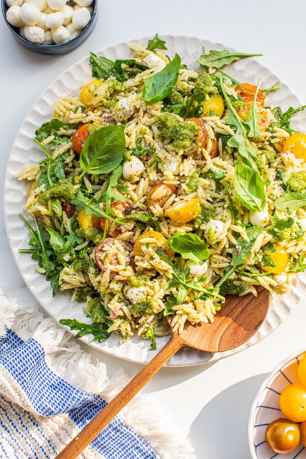 a serving of orzo salad with arugula, tomatoes, and mozarella