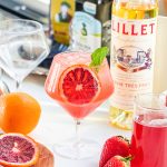blood orange strawberry spritz garnished with a slice of orange