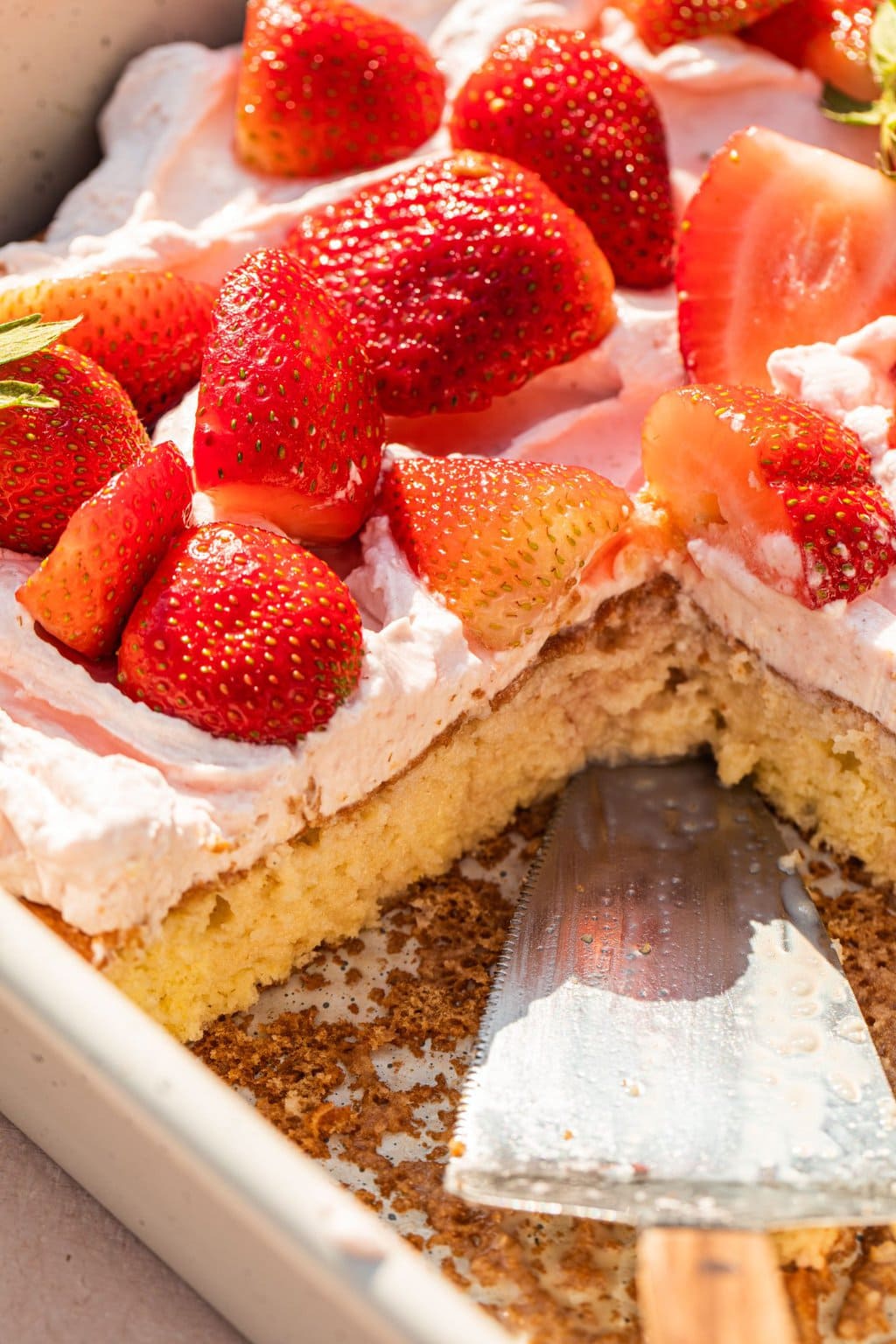 strawberries on top of the cake with a slice cut out of it