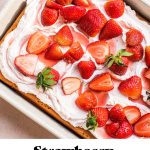 strawberry tres leches cake topped with fresh strawberries