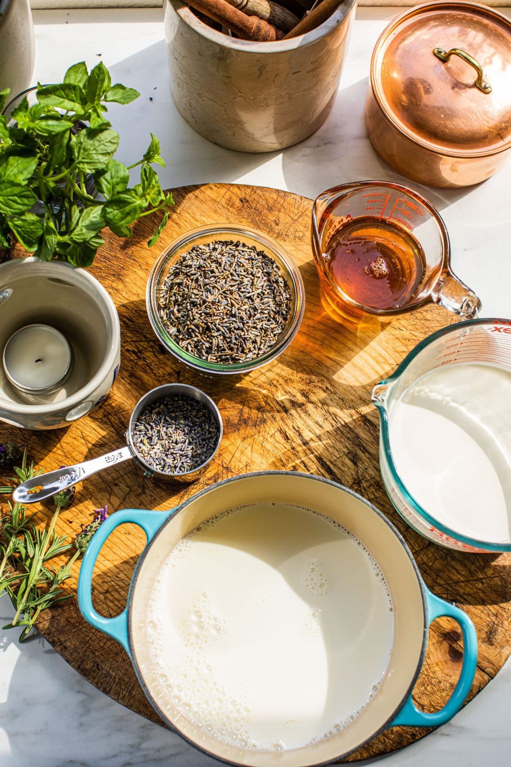 a bowl of lavender buds, a pot of cream, some honey, and whole milk to make lavender honey ice cream