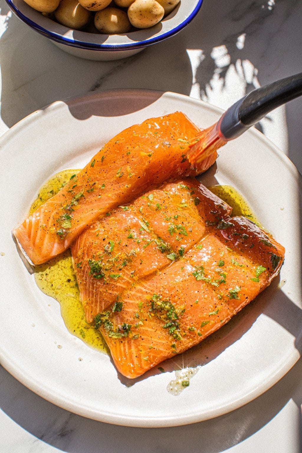 three salmon filets drizzled in marinade