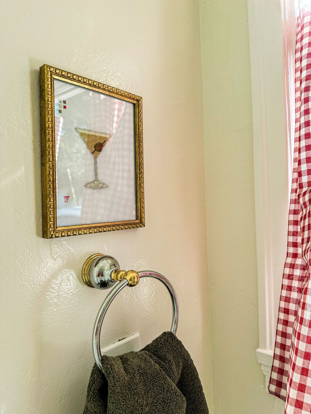 The needlepoint martini hanging over a handtowel 