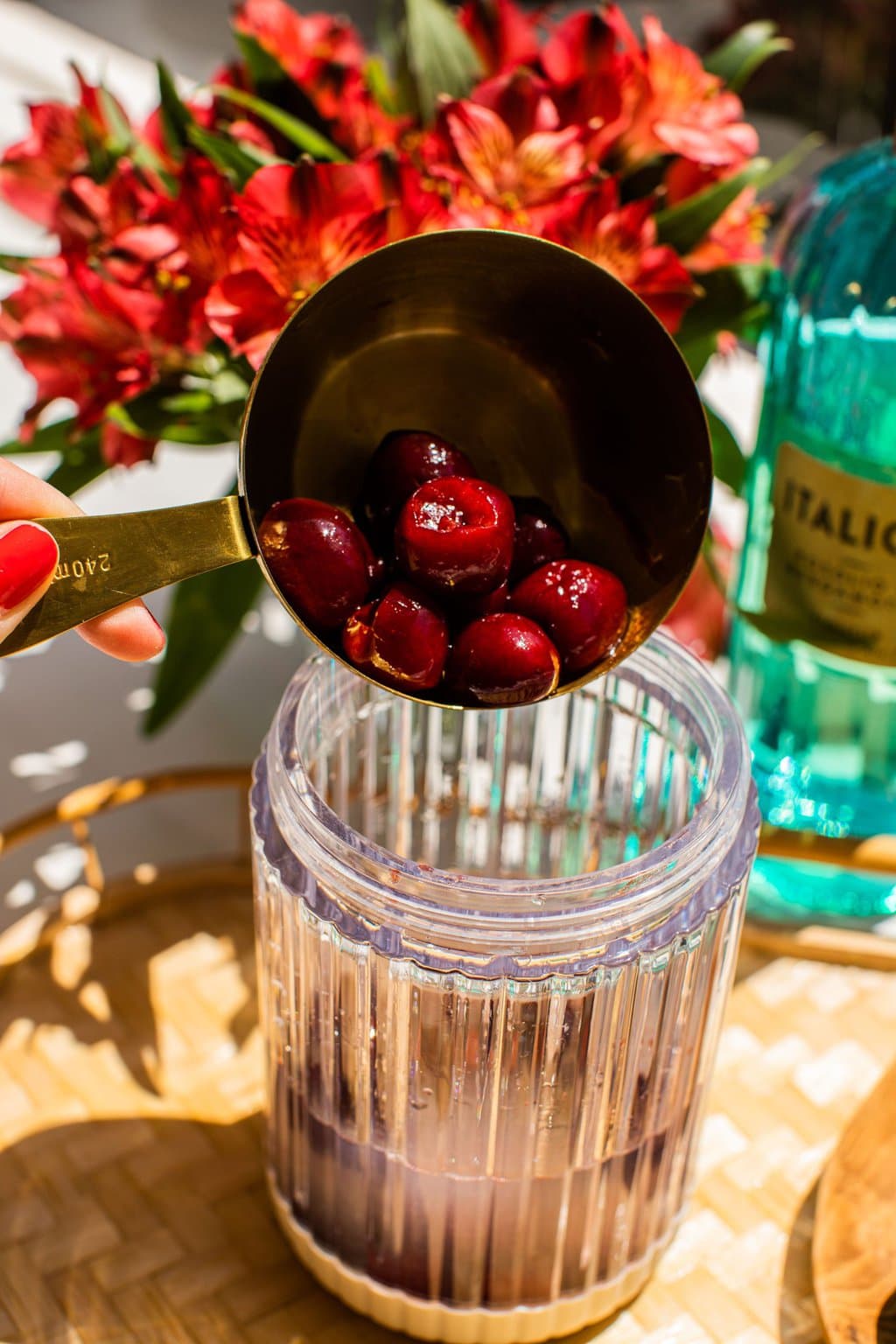 adding cherries to a blender with the other ingredients