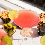 a cosmo cocktail with a lime wedge garnish