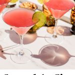 a couple glasses of a cosmo garnished with lime wheels with text overlay