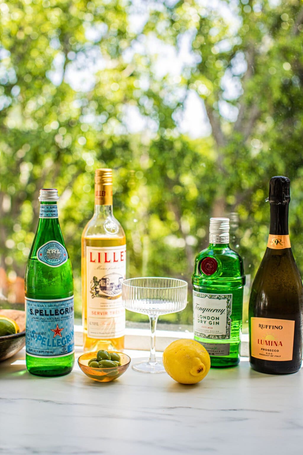 lemon, olive, olive oil, pellegrino, gin, prosecco, and lillet