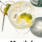 an overhead shot of a martini spritz with olives and lemon rind inside it along with text overlay at the bottom