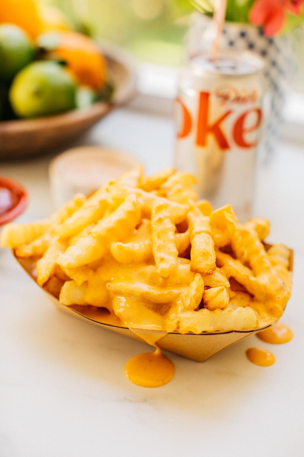 fries covered in cheese sauce that's dripping out of the bowl onto the countertop