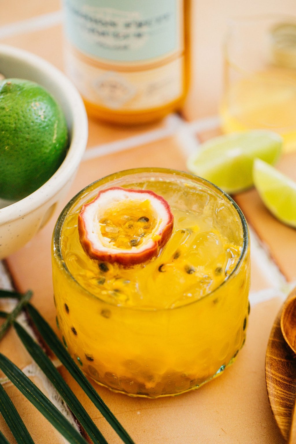 a glass full of orange passion fruit spritz with a slice of fruit on top