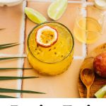 a passionfruit spritz in a glass with a piece of fruit on top, limes around it, and text overlay