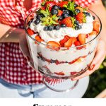 A photo of elizabeth holding the berry trifle with text overlay beneath it