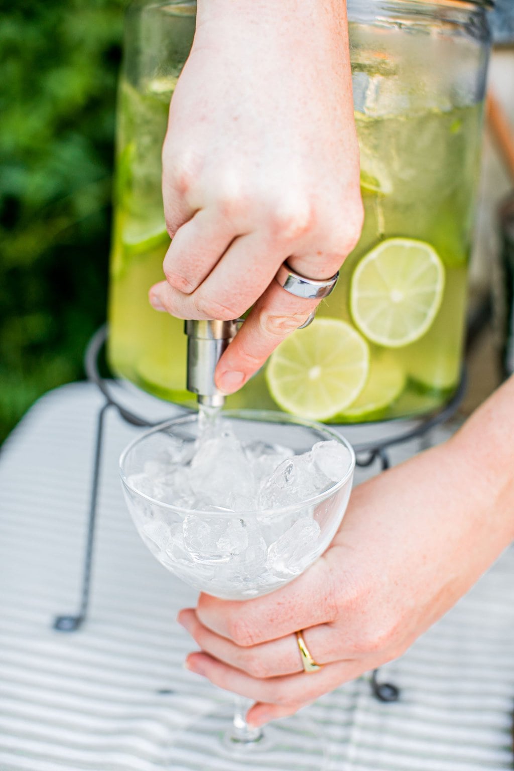 pouring a hugo spritz from the spout on a large pitcher