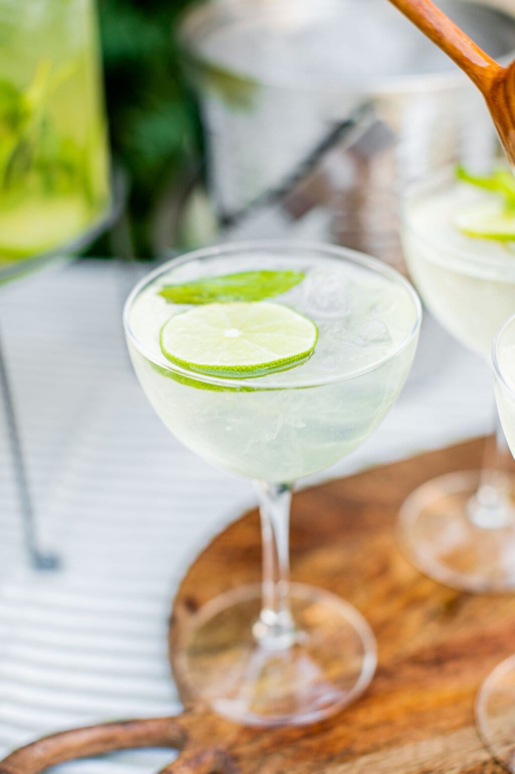 a glass full of an elderflower spritz with a lime wheel and mint leaf for garnish