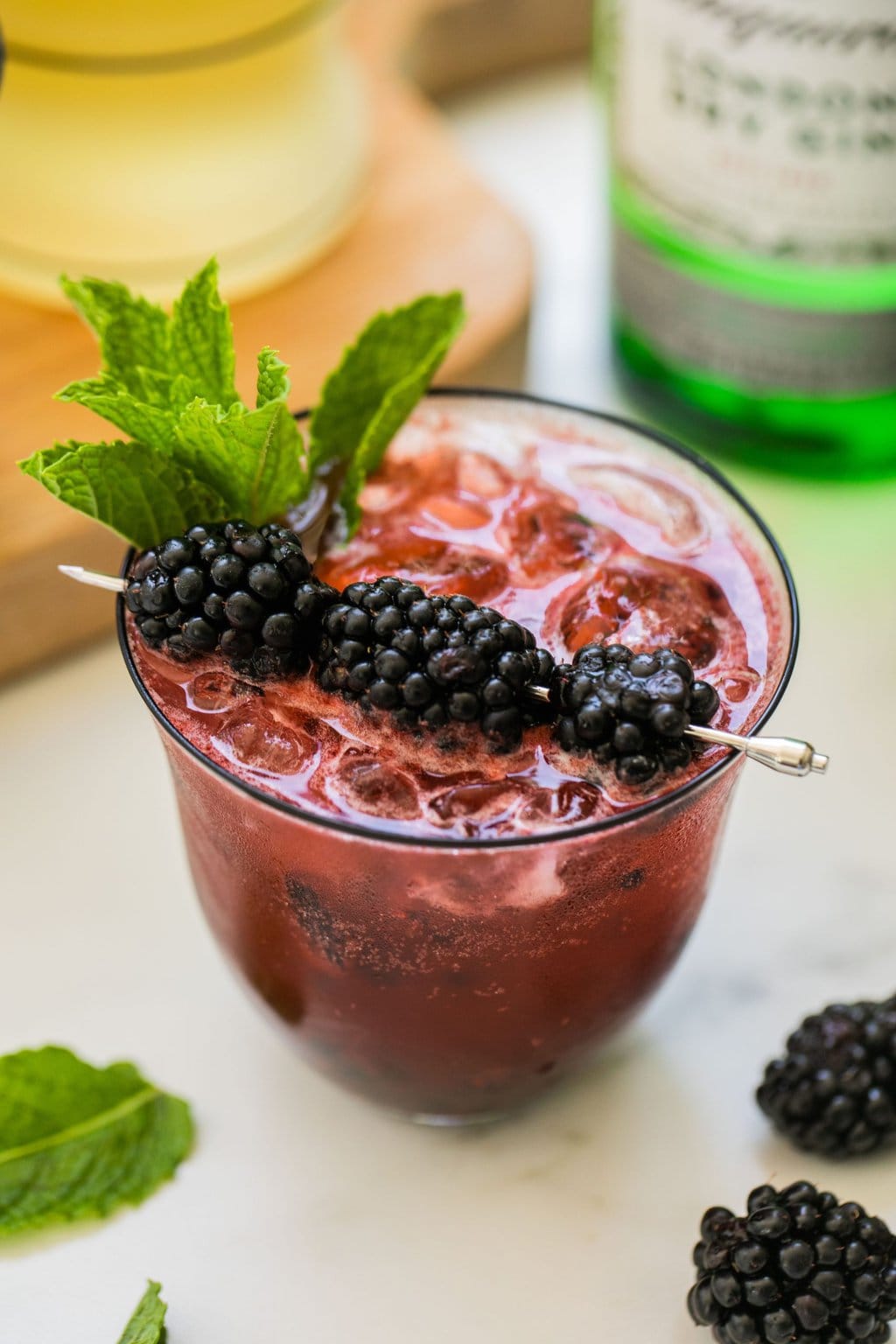 a blackberry gin spritz garnished with blackberries and mint