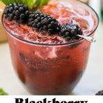 a blackberry gin spritz garnished with blackberries and mint with text overlay