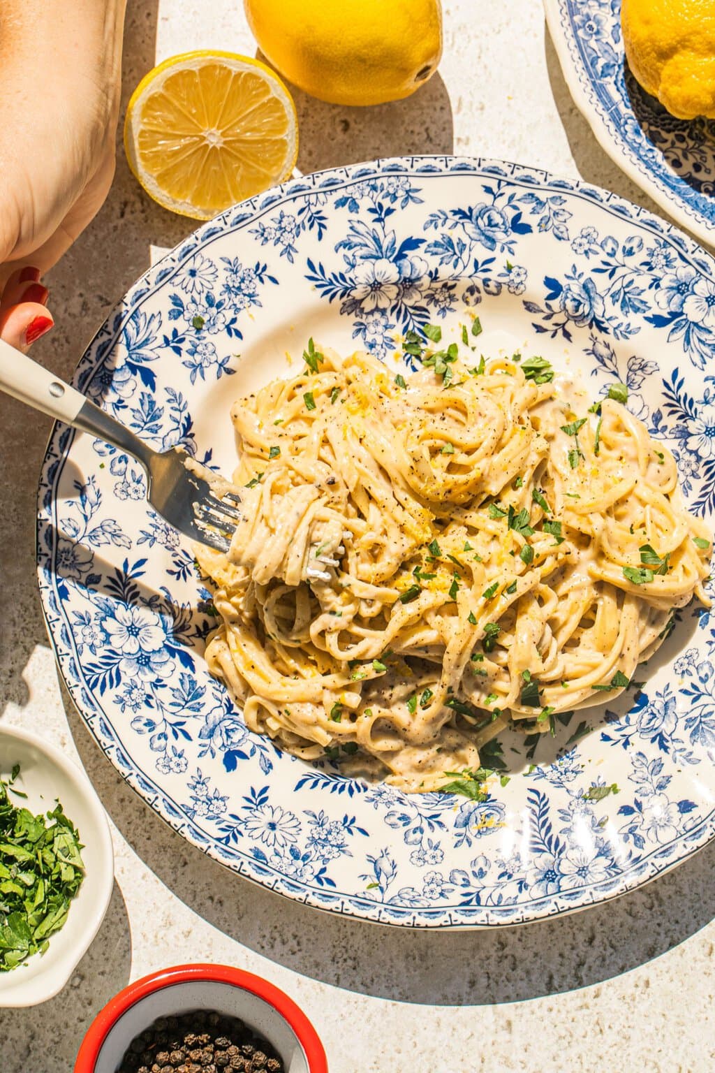 a large bowl of lemon pasta with some of it twirled on a fork 