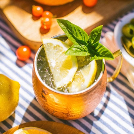 a copper mug full of limoncello mule garnished with lemon slices and mint leaves