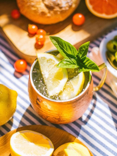 a copper mug full of limoncello mule garnished with lemon slices and mint leaves