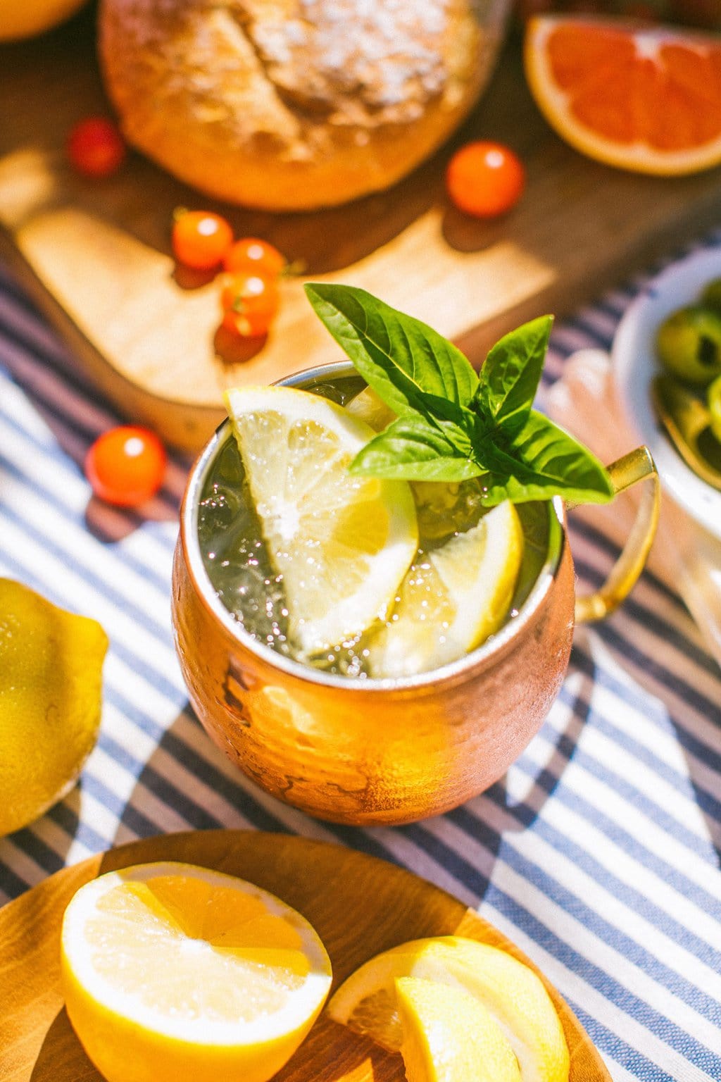 a copper mug full of limoncello mule garnished with lemon slices and mint leaves