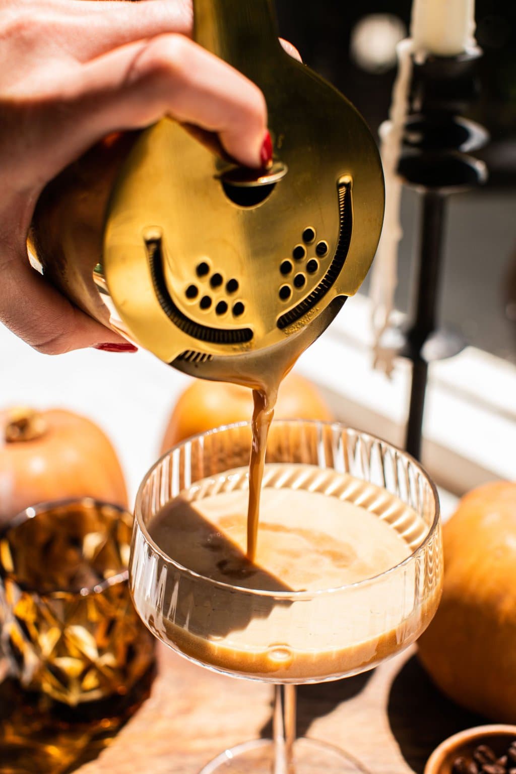 straining the pumpkin espresso martini into the glass