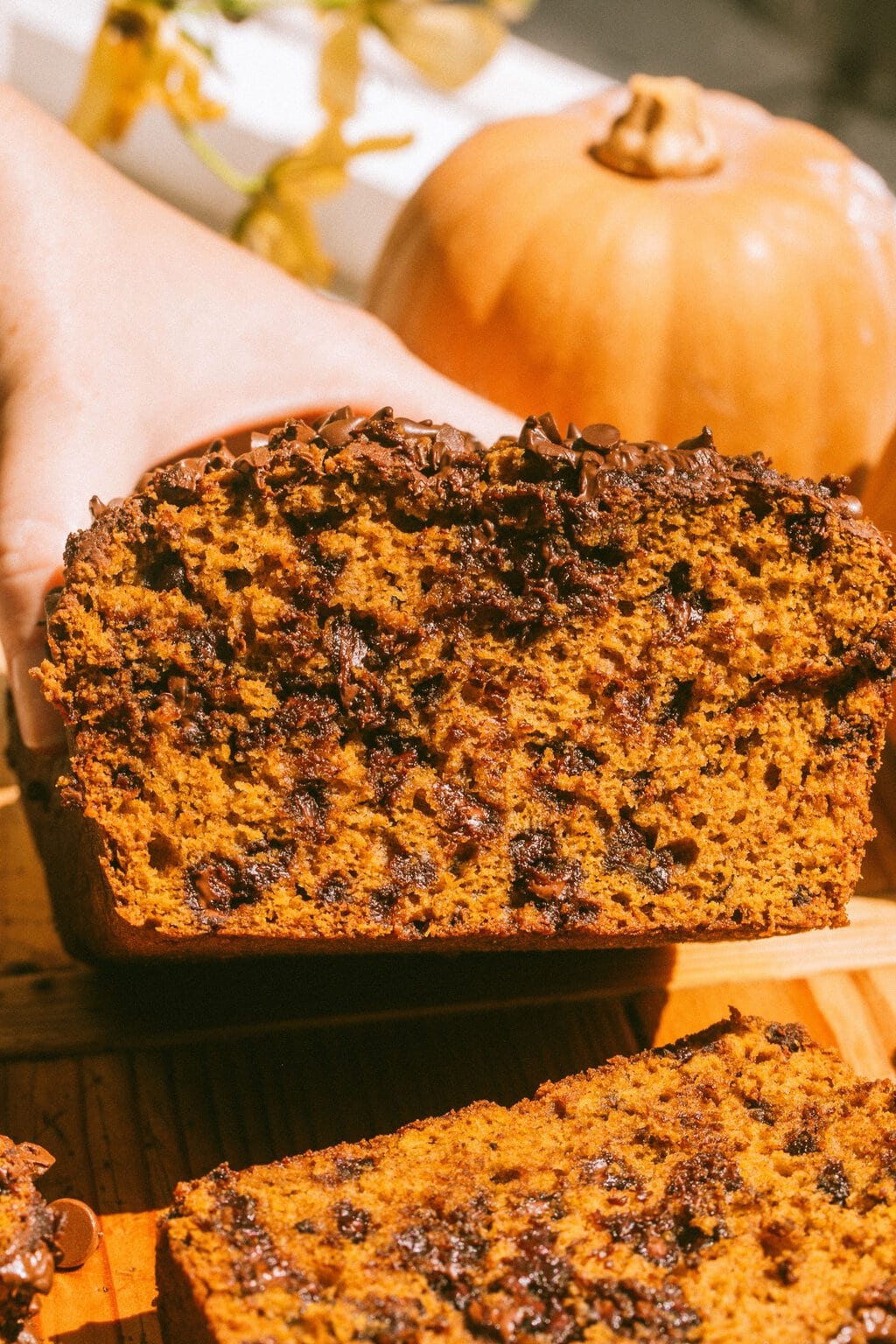 a loaf of pumpkin bread with chocolate chips cut in half so you can see the inside