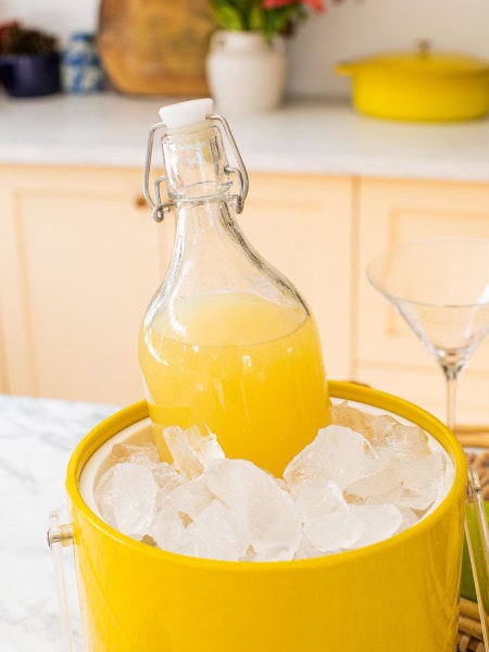 a large carafe of pear martini chilling in a yellow ice bucket