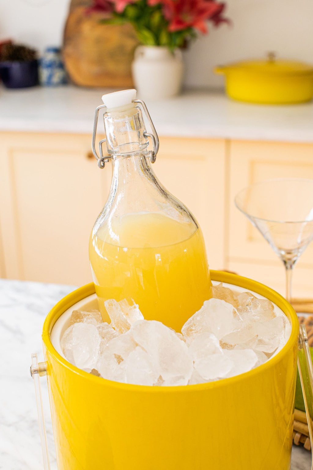 a large carafe of pear martini chilling in a yellow ice bucket