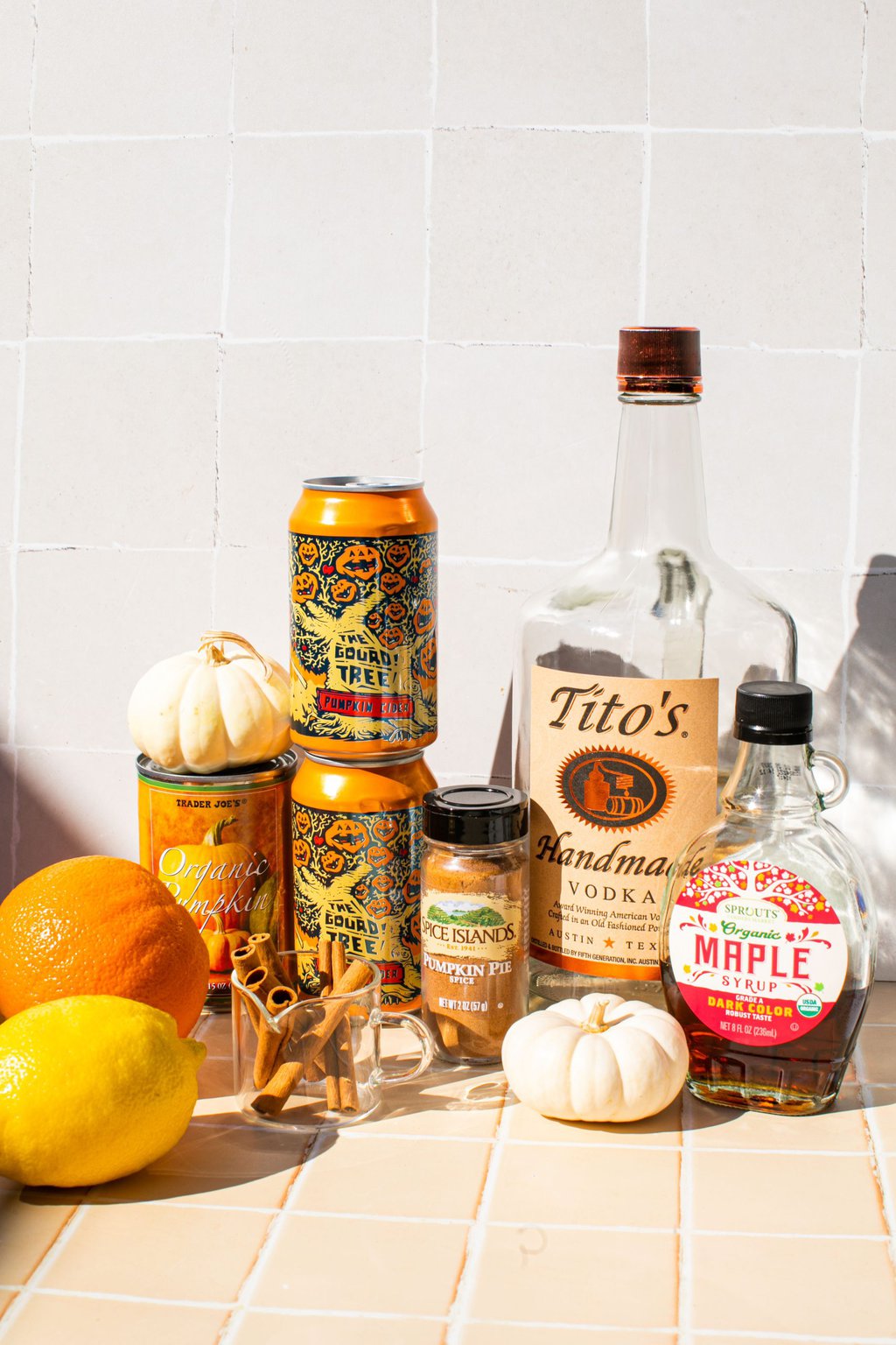 titos, pumpkin cider, pumpkin puree, pumpkin pie spice, cinnamon sticks, oranges, lemons, maple syrup and mini white pumpkins