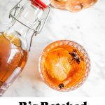 an overhead photo of an old fashioned in a glass with a swing top bottle full of more cocktail mix hovering above it