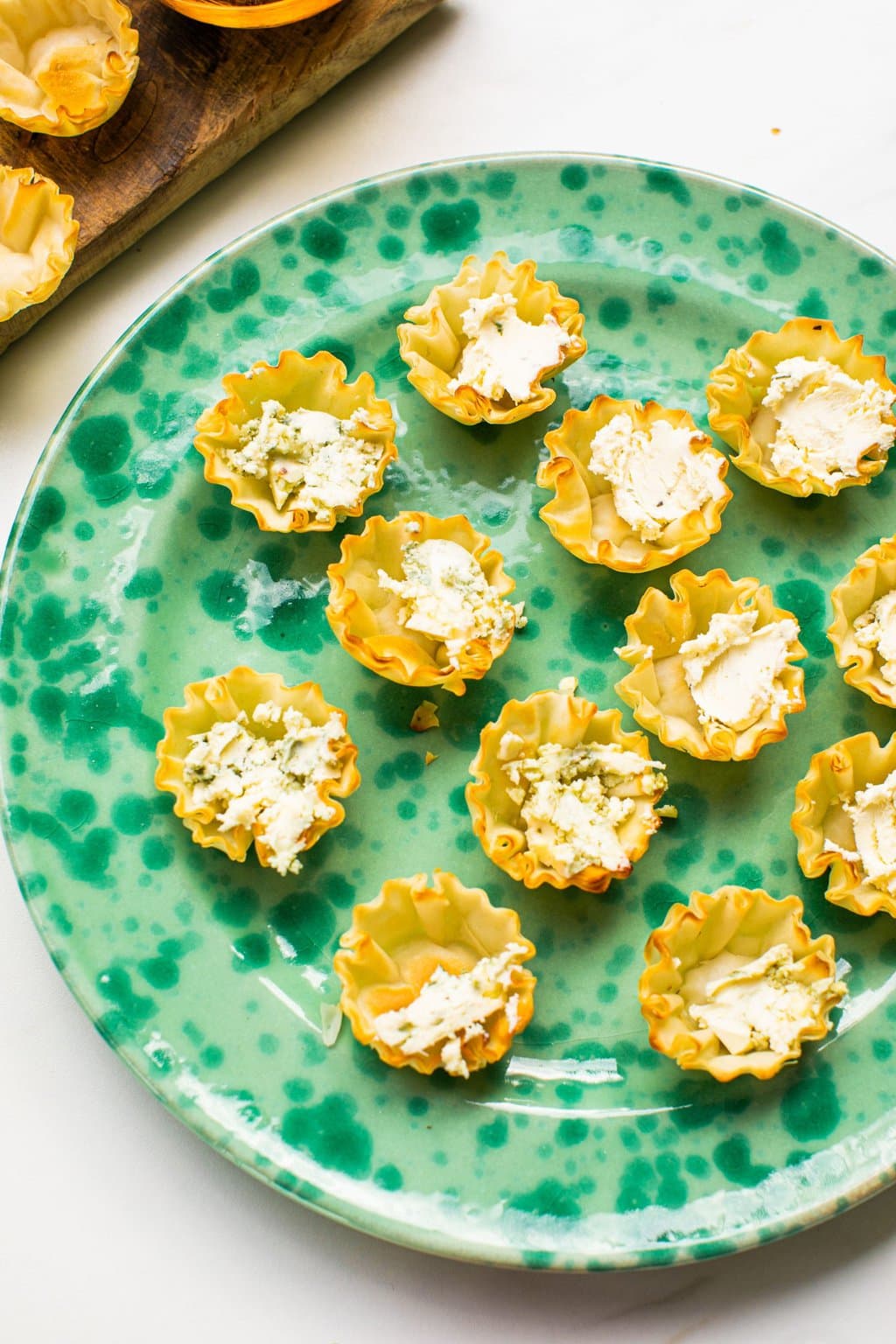 phyllo shells filled with boursin and blue cheese on a green plate