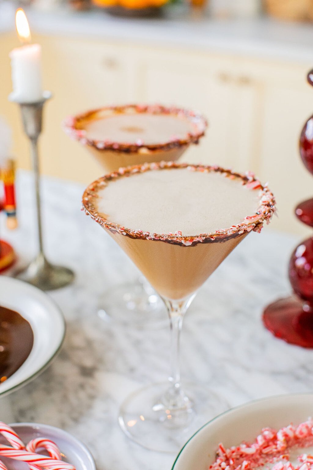 a photo of two peppermint espresso martinis rimmed with chocolate syrup and crushed candy canes