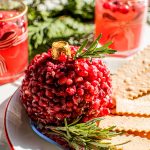 pomegranate ornament christmas cheeseball on a plate with crackers