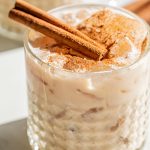 a white russian drunk with cinnamon sticks and cinnamon powder garnish on top